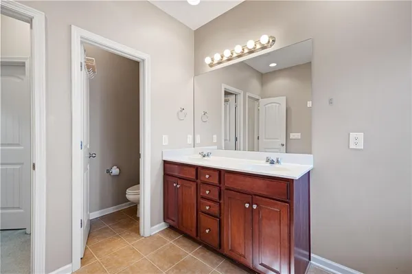 a spacious bathroom with a double vanity sink a large mirror and a shower