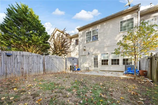 a view of a house with a yard and wooden fence