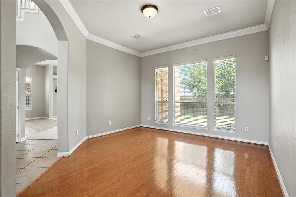 8220 Holliday Road Lantana, TX 76226 - Photo 8 of 40 Spacious room featuring wood-finish flooring, light grey walls, and white crown molding