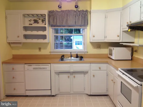 a kitchen with white cabinets and sink