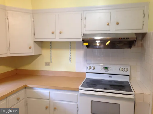 a kitchen with white cabinets and appliances