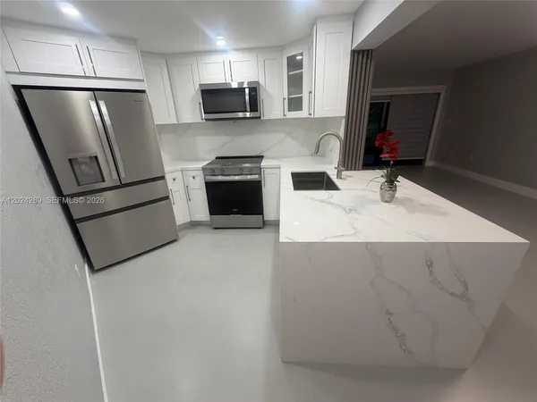 a kitchen with stainless steel appliances a refrigerator stove microwave and sink