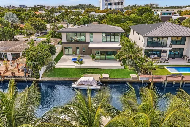 an aerial view of a house with swimming pool patio and lake view