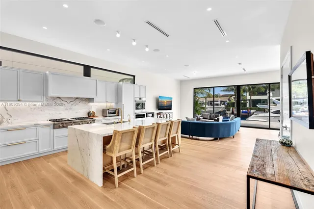 a kitchen with a sink stove and white cabinets with wooden floor