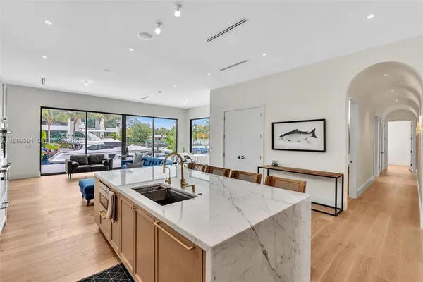 a kitchen with stainless steel appliances granite countertop a sink a counter space and living room view
