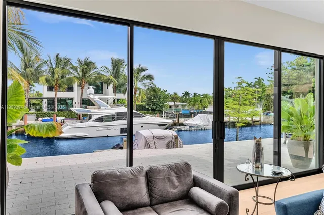 a living room with patio furniture and a floor to ceiling window