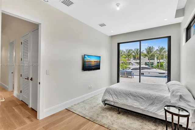 a bedroom with a bed and a flat tv screen next to a window