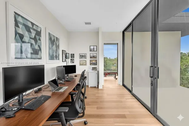 a view of a workspace with furniture and a window