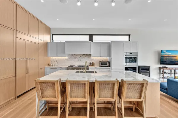 a kitchen with a table chairs refrigerator and cabinets