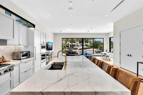 a large white kitchen with sink and cabinets