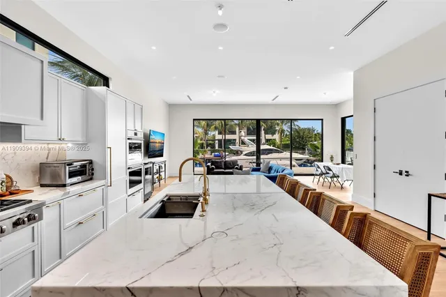 a large white kitchen with sink and cabinets