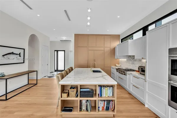 a kitchen with stainless steel appliances granite countertop a stove a sink and a refrigerator