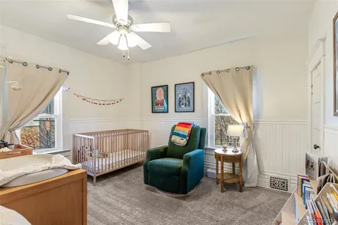 a bedroom with a bed and a mirror on the dresser