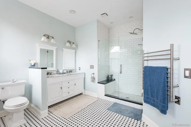 a large bathroom with a sink a toilet a large mirror and shower