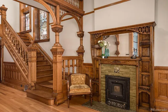a living room with a fireplace windows and a ceiling fan