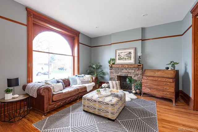 a living room with furniture a fireplace and a large window