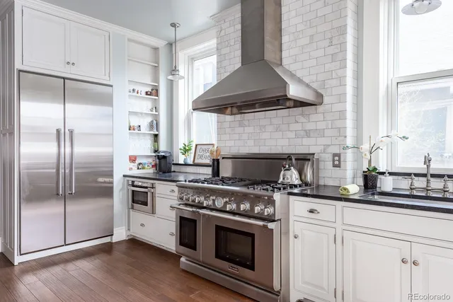 a kitchen with stainless steel appliances a stove a sink and a refrigerator
