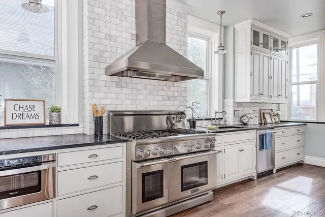 a kitchen with granite countertop white cabinets stainless steel appliances and a sink