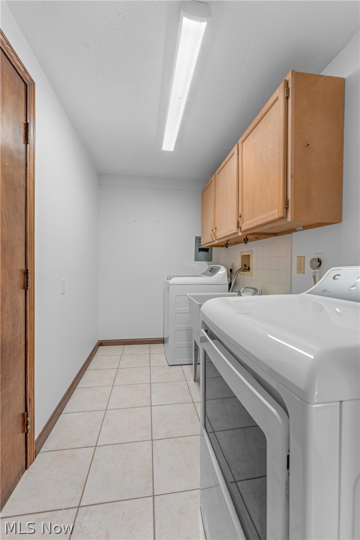 2941 Copley Road Akron, OH 44321 - Photo 26 of 44 Laundry area featuring cabinet space, light tile patterned floors, and a textured ceiling