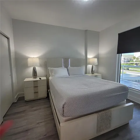 a bedroom with a bed and a view of living room