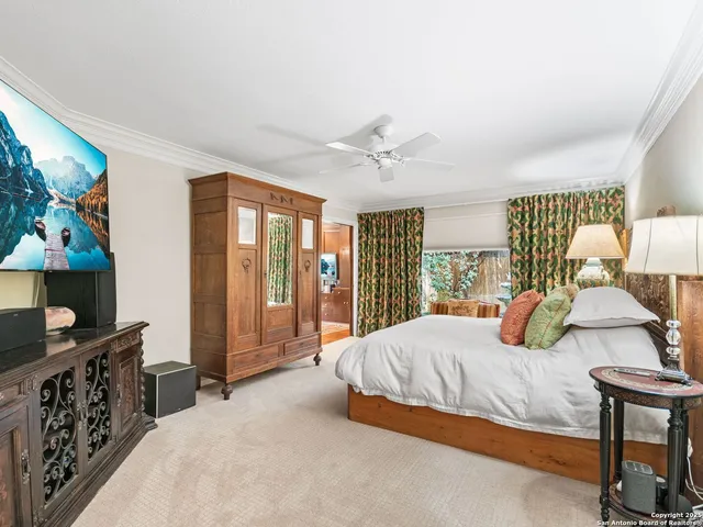 a bedroom with a large bed and a chandelier