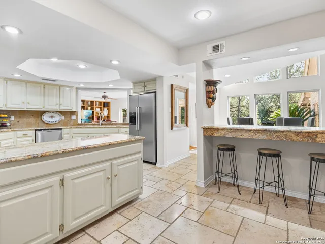 a kitchen with a dining table chairs and white cabinets
