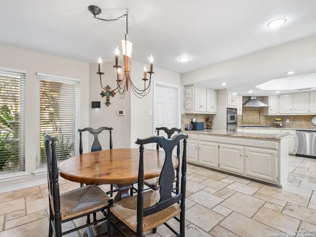 a kitchen with white cabinets appliances and a sink
