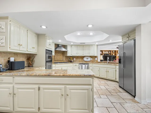 a kitchen with stainless steel appliances granite countertop a sink and cabinets