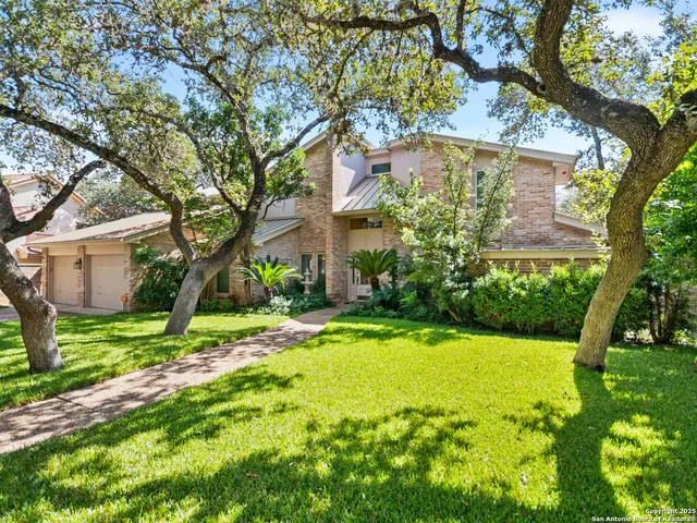 a view of a house with a yard and tree s