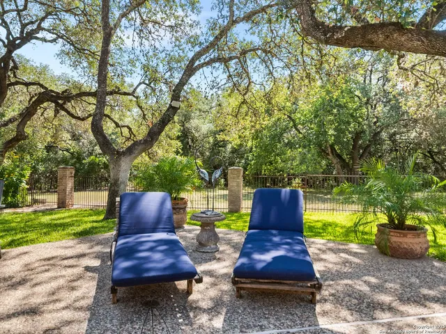 a view of a swimming pool with chairs and table in the patio