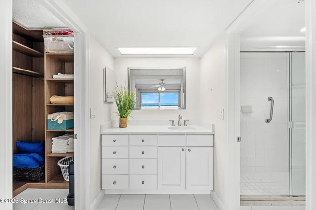 a bathroom with a granite countertop sink a mirror and a potted plant
