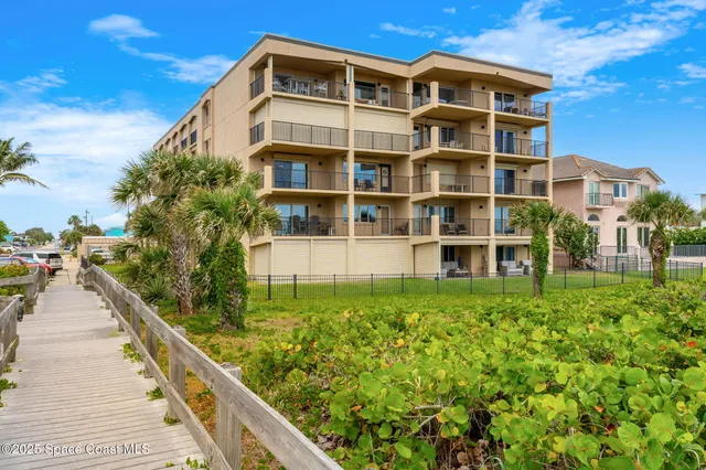 a view of a balcony with floor to ceiling windows and wooden fence
