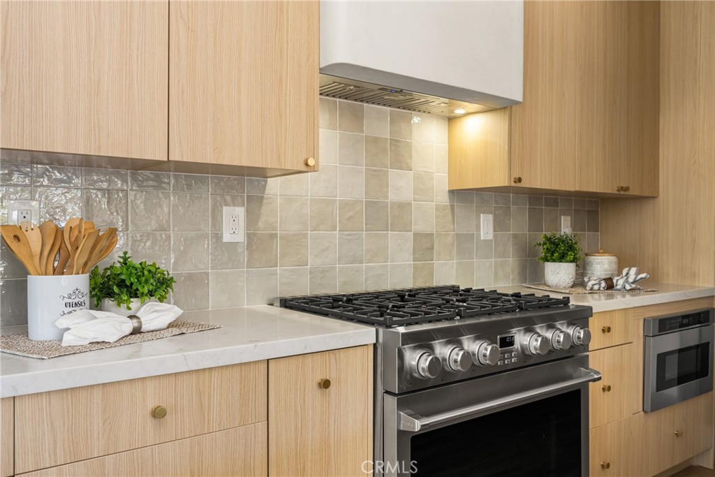 2680 Chatwin Avenue Long Beach, CA 90815 - Photo 32 of 61 a kitchen with granite countertop stainless steel appliances a stove a sink and a white cabinets