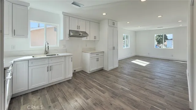 a kitchen with white cabinets appliances and sink