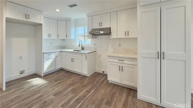 a kitchen with white cabinets and stainless steel appliances