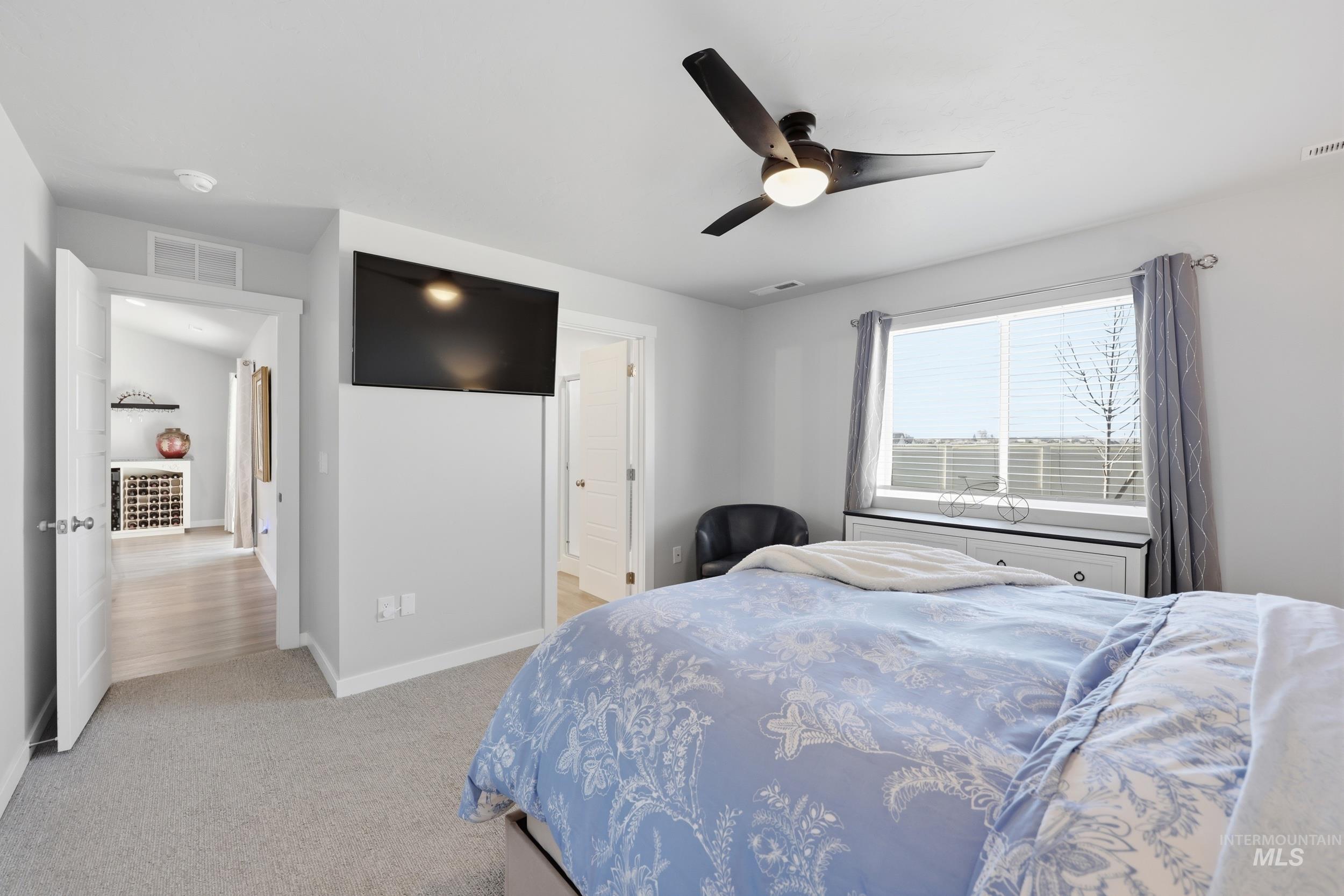 3697 W Lane Meridian, ID 83642 - Photo 23 of 44 Bedroom with ensuite bathroom, ceiling fan, and light carpet
