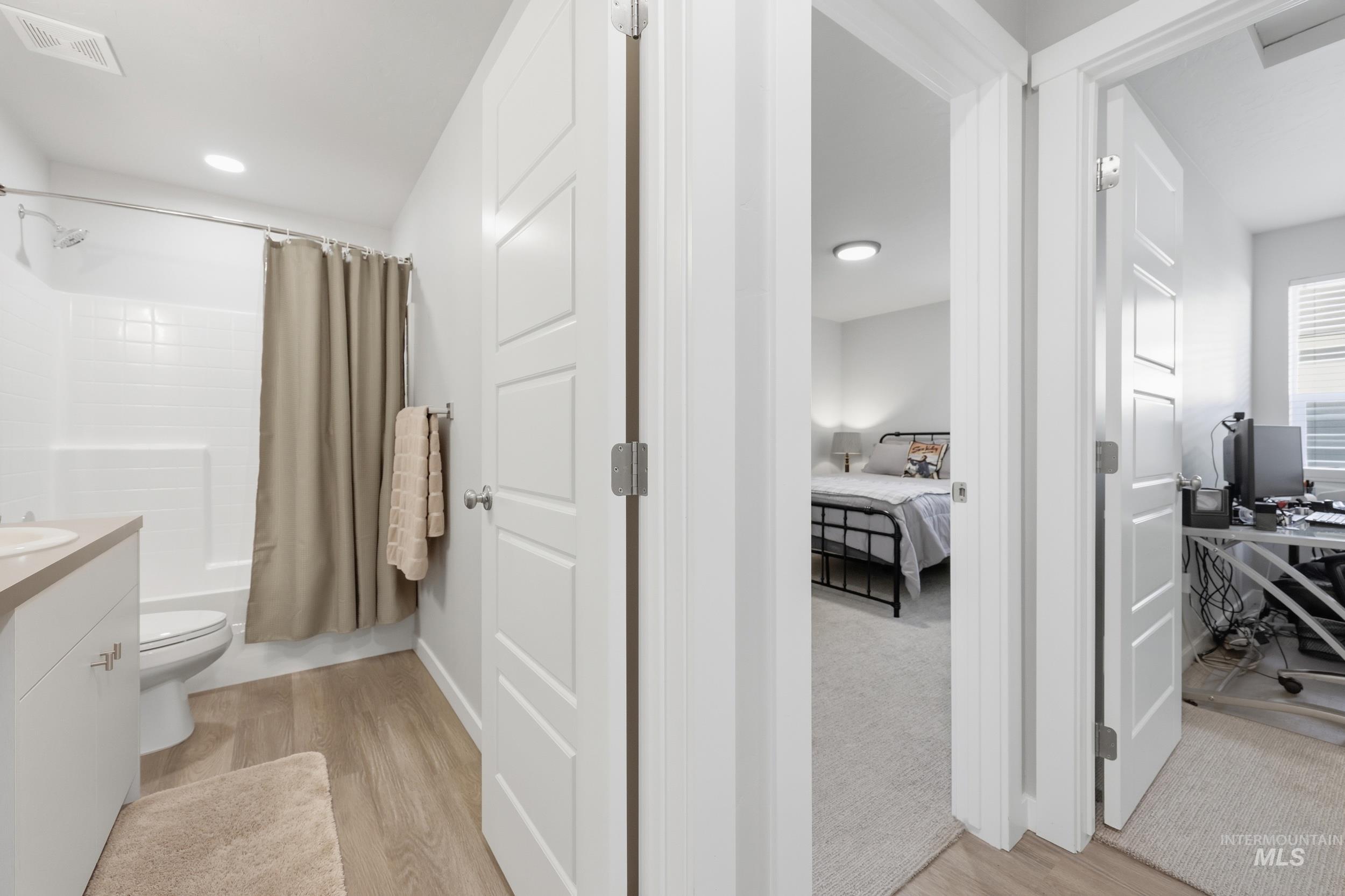 3697 W Lane Meridian, ID 83642 - Photo 29 of 44 Full bath with vanity, connected bathroom, shower / bathtub combination with curtain, and LVP flooring