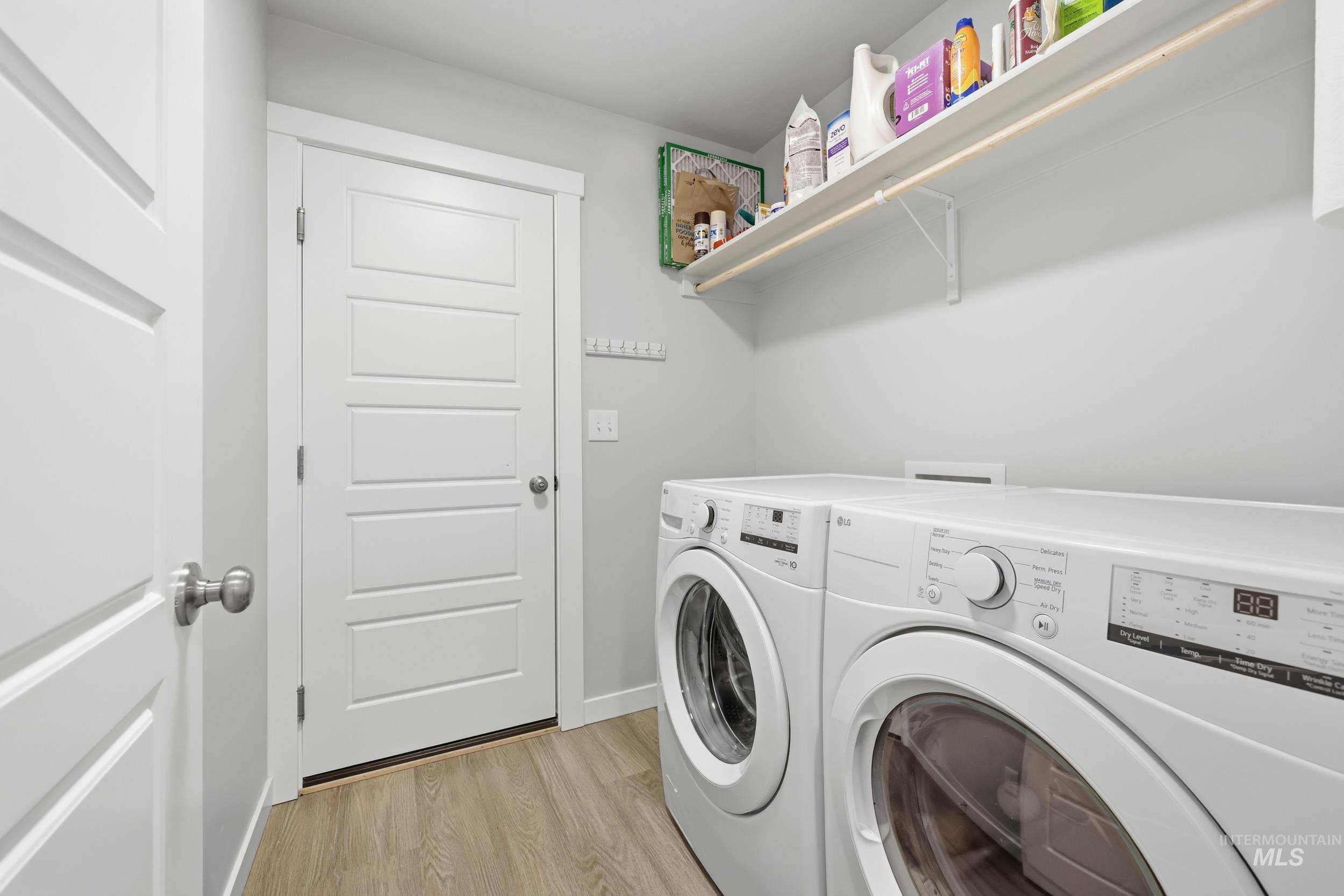3697 W Lane Meridian, ID 83642 - Photo 31 of 44 Laundry room featuring LVP floors and independent washer and dryer. Storage shelf, and clothes drying rack. Paper towel holder, and key hook rack.