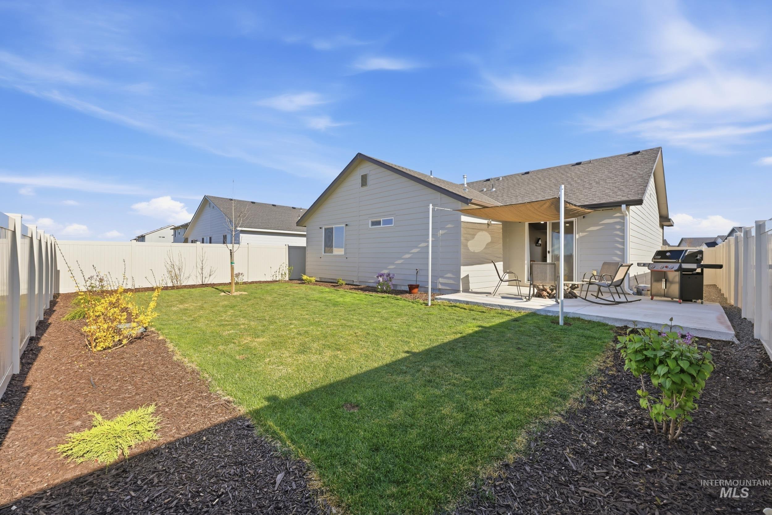 3697 W Lane Meridian, ID 83642 - Photo 35 of 44 Back of property with a fenced backyard, a patio, automatic sprinkler system and drip system. Many perrenial plants.
