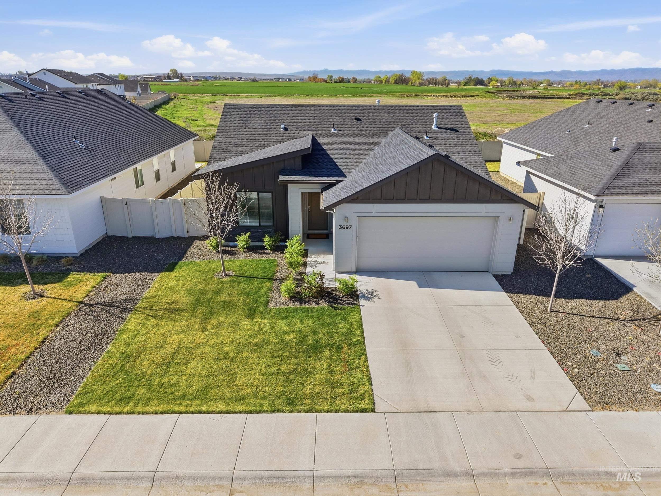 3697 W Lane Meridian, ID 83642 - Photo 4 of 44 View of front of property featuring board and batten siding, a shingled roof, concrete driveway, and a garage