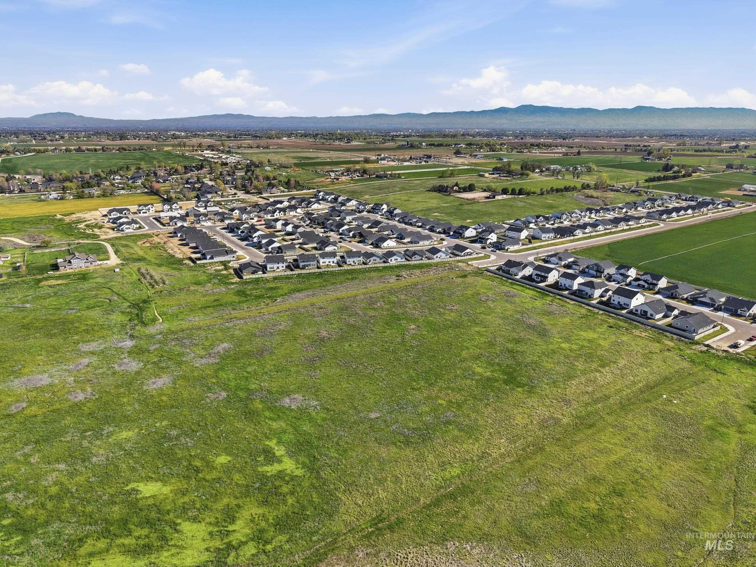 3697 W Lane Meridian, ID 83642 - Photo 40 of 44 Aerial view of property's location featuring a mountainous background and field behind.