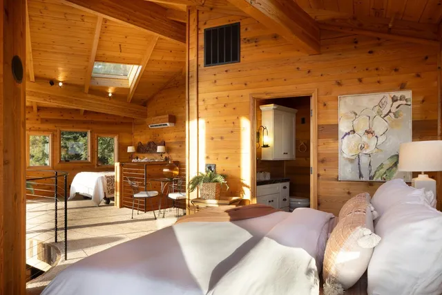 a bedroom with a large bed and large windows