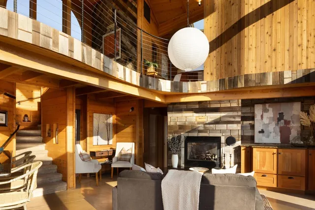 a living room with fireplace furniture and a large window