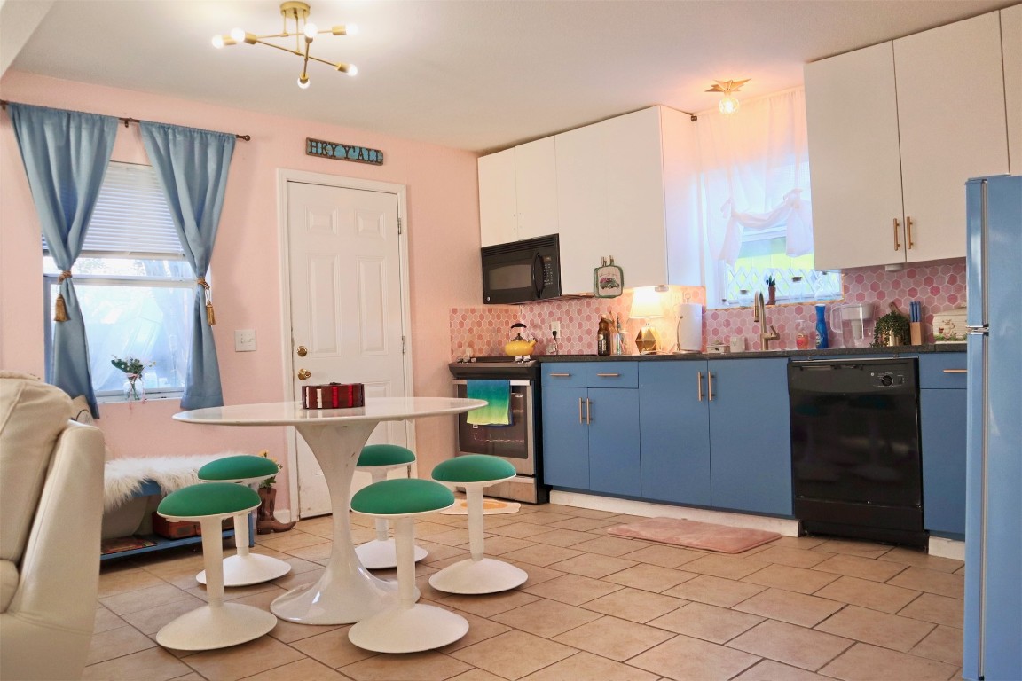 1007 Johnson Street Lockhart, TX 78644 - Photo 2 of 15 a kitchen with a stove a sink and a dining table