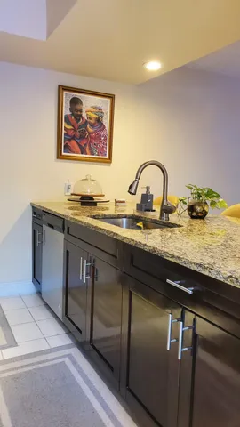 a kitchen with stainless steel appliances granite countertop a sink a stove and wooden floors