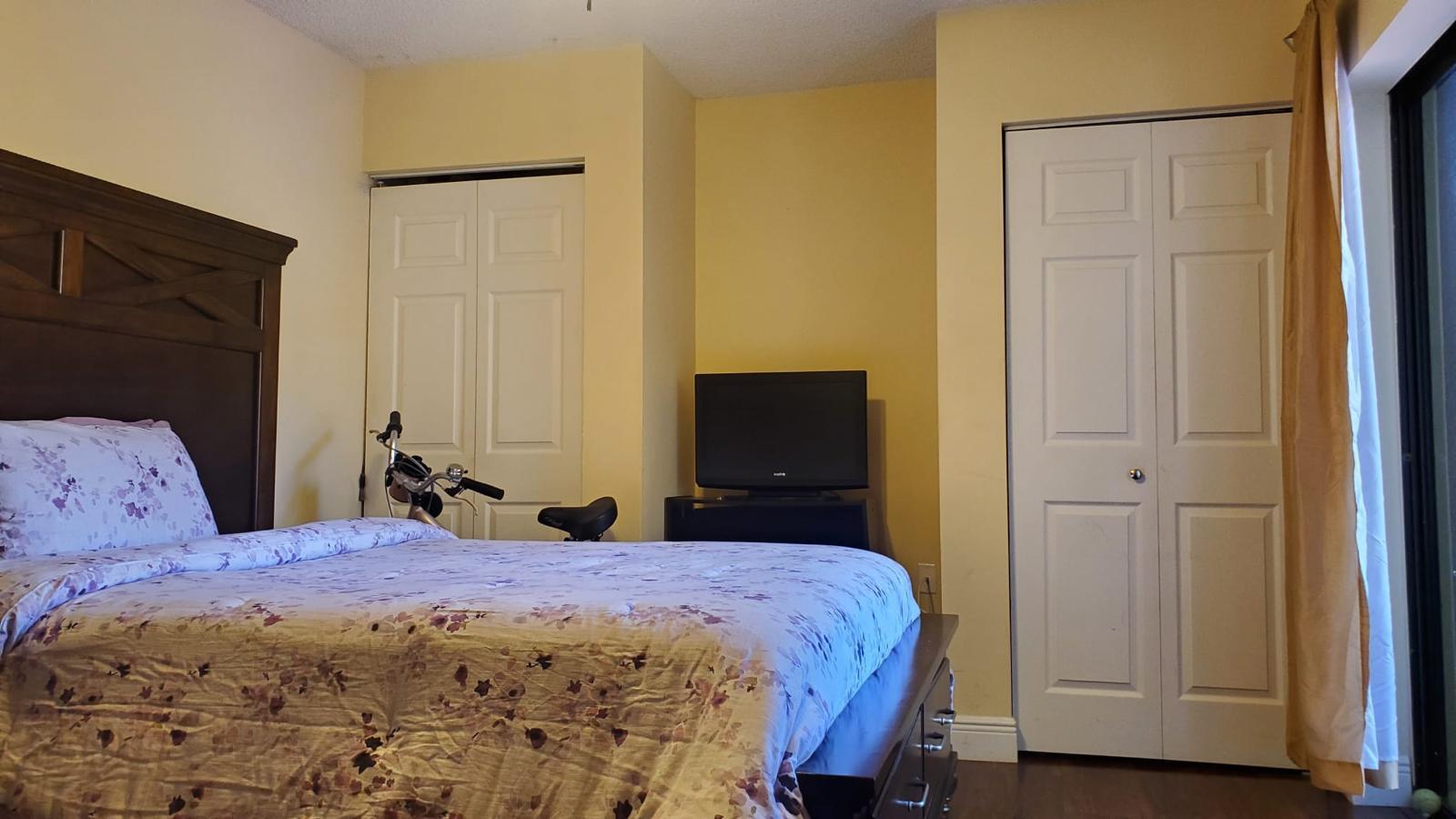 2116 21st Lane, Unit 2116 Greenacres, FL 33463 - Photo 9 of 14 a bedroom with a bed and a mirror