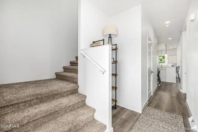 a view of a hallway with wooden floor and staircase