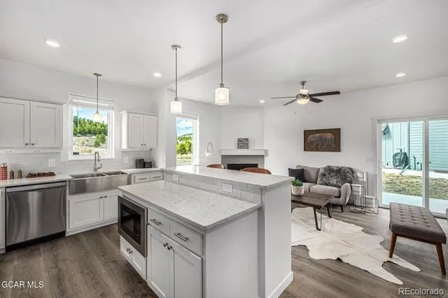 a kitchen with a stove a sink a dining table and chairs