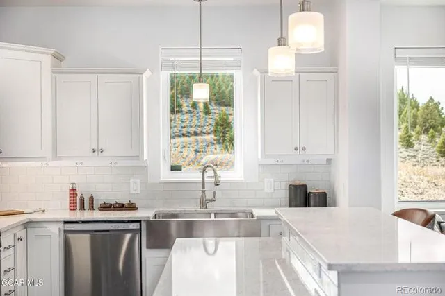 a kitchen with stainless steel appliances granite countertop a sink window and cabinets