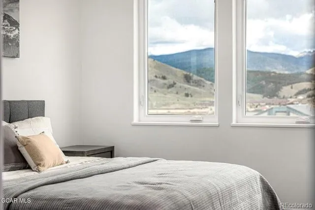 a bedroom with a bed and a painting on the wall